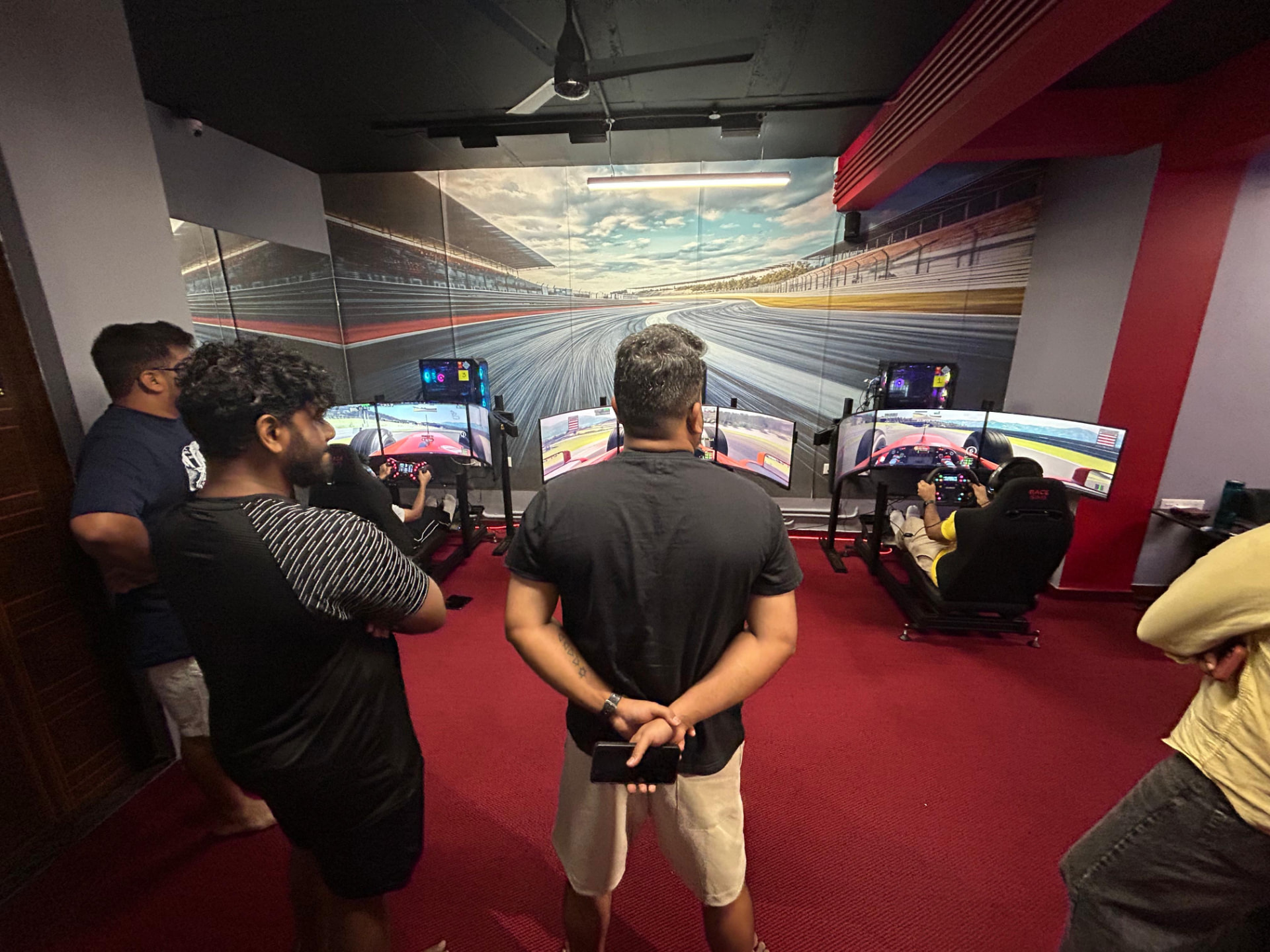 NiyuSuki sim racing venue in Kochi with three direct-drive racing rigs and triple-screen setups